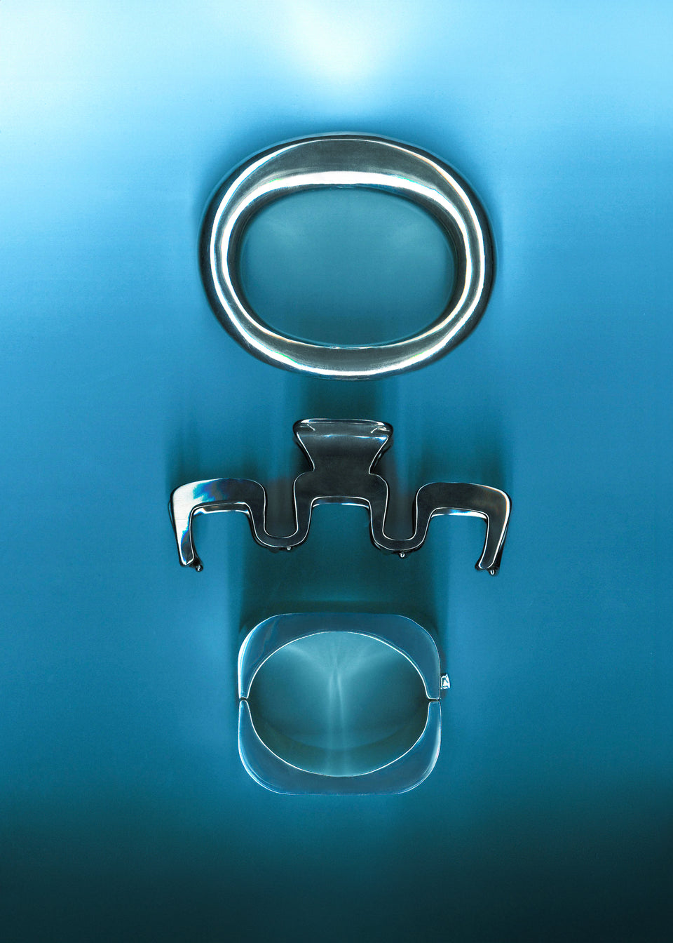 a scan of silver accessories on a blue background