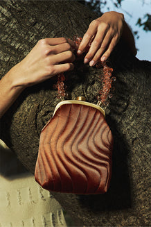 Image of a bronze handbag with a beaded handle.